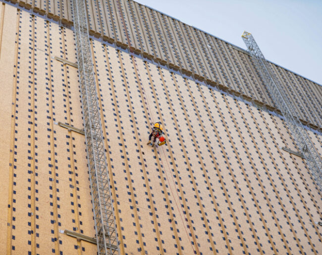 Man scaling a brown building