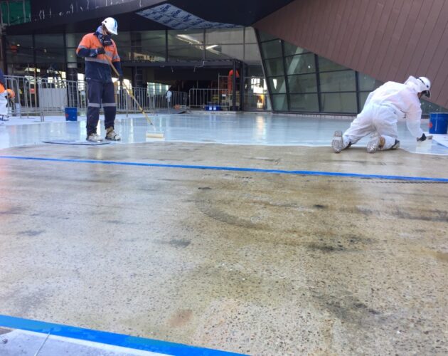 Waterproofing solutions in the form of waterproofing membrane, with several team members of Duratec on the worksite in Australia wearing PPE gear.
