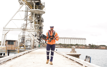 Aden Peterson walking down Flinders Port dock with drone in hand.