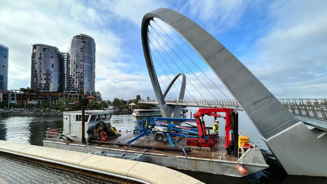 Elevated Working Platform (EWP) mounted on barge underneath Elizabeth Quay Pedestrian Bridge.