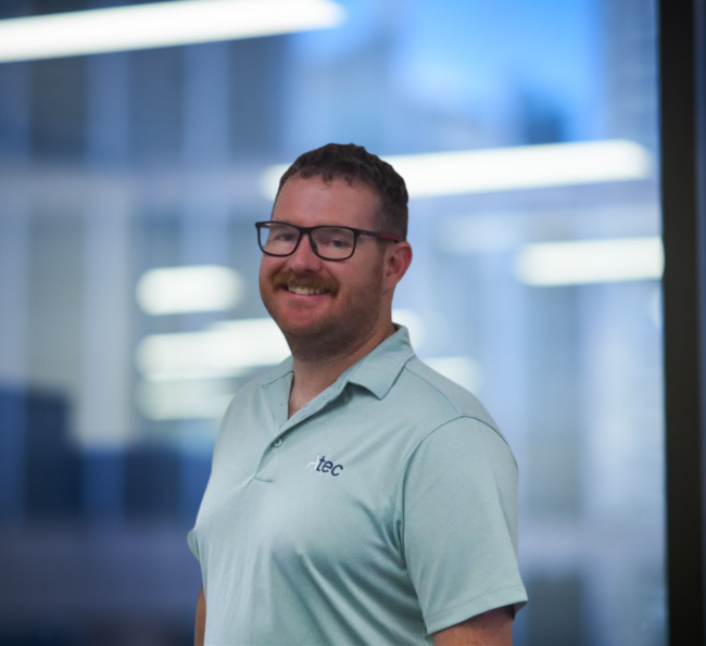 Professional portrait of Ian Costley, Senior Facade Design Manager at Atec Facades, standing in an office environment.